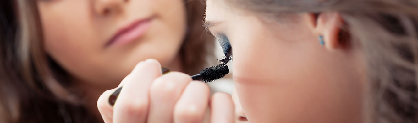 Woman applying mascara to a guest