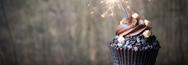 Chocolate cupcake with chocolate toppings and a sparkler candle